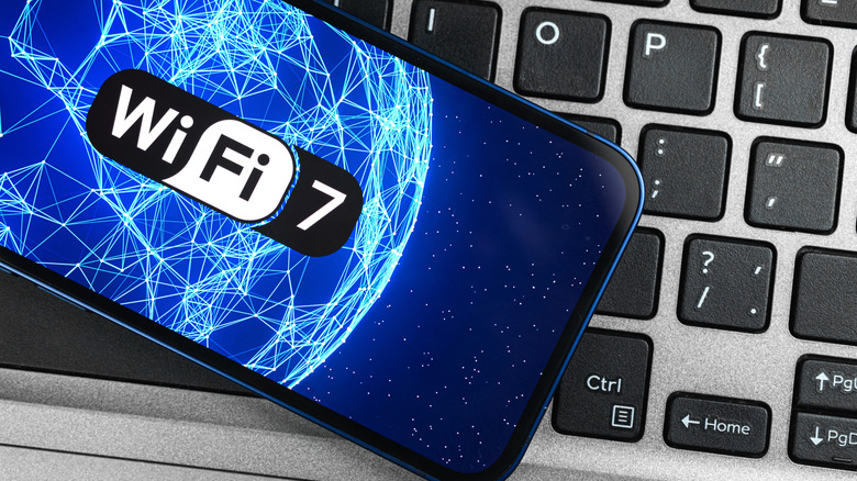 Wi-Fi 7 logo on a smartphone placed on a laptop keyboard.