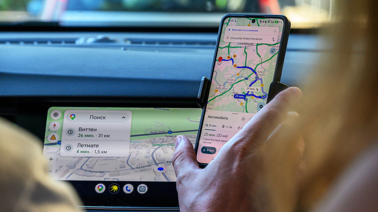 A driver interacts with Google Maps on their phone and their Android Auto head unit.