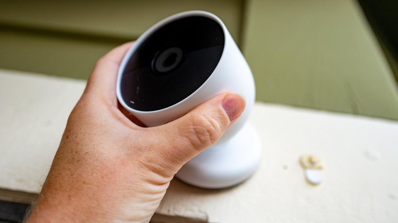 A person placing a Nest camera on a flat surface.