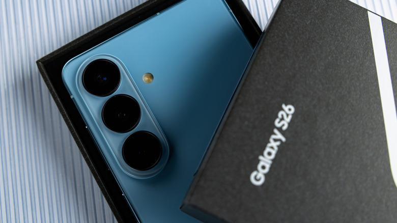 The Samsung Galaxy S26, partially obscured by its box lid.