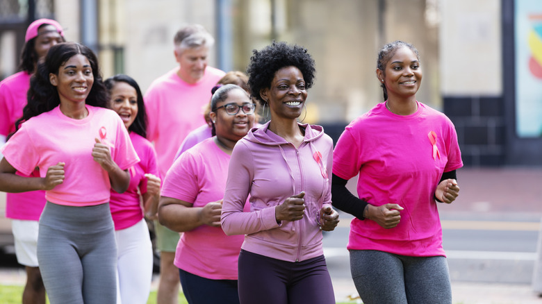 A group of people all in pink shirts walking for exercise