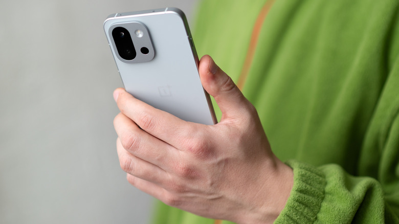 a person holding a OnePlus 13T in their hands