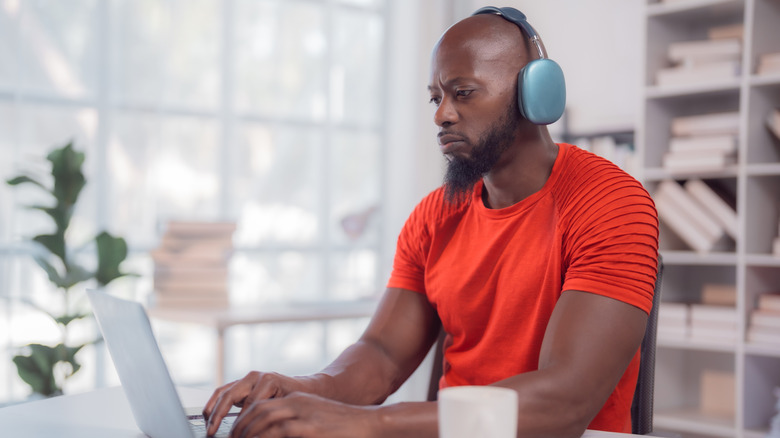 A man boosts office productivity by wearing headphones
