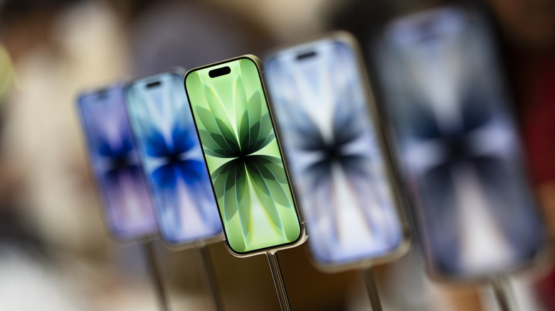 Multiple iPhones showing the same patterned background with different colors on each device, with the green patterned-iPhone being the most prominent