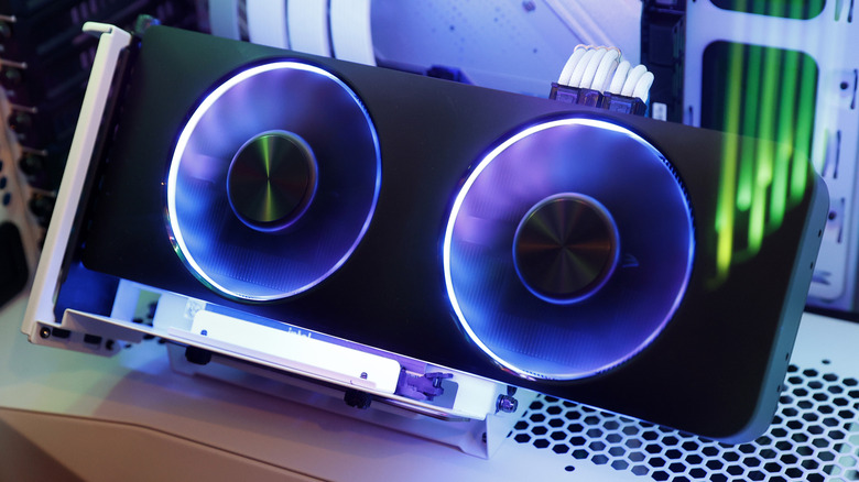 A black Intel Arc A750 GPU with two spinning fans placed atop a white PC case.