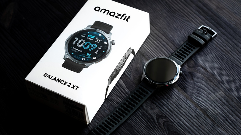 Amazfit Balance 2 XT smartwatch sitting next to its retail packaging with screen off.
