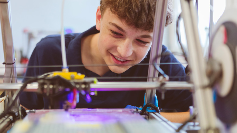 young person watching a 3D printer
