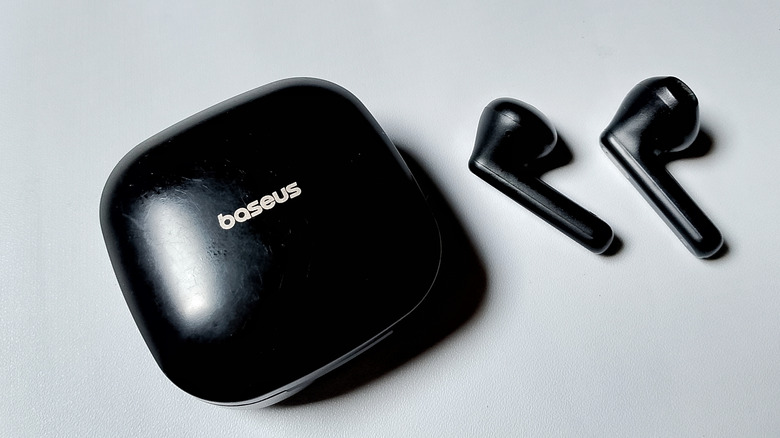 Baseus earphones on a white table.