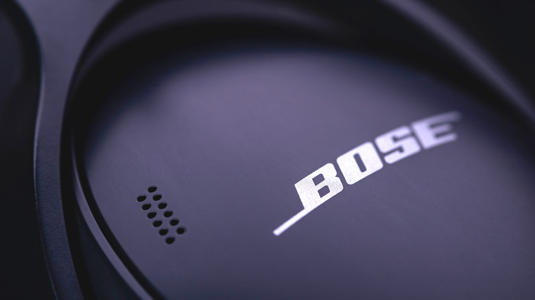 A macro shot of a pair of Bose headphones, focussing on a single ear cup and Bose logo