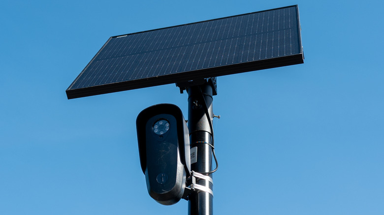 A Flock camera and its solar panel attached to a pole.