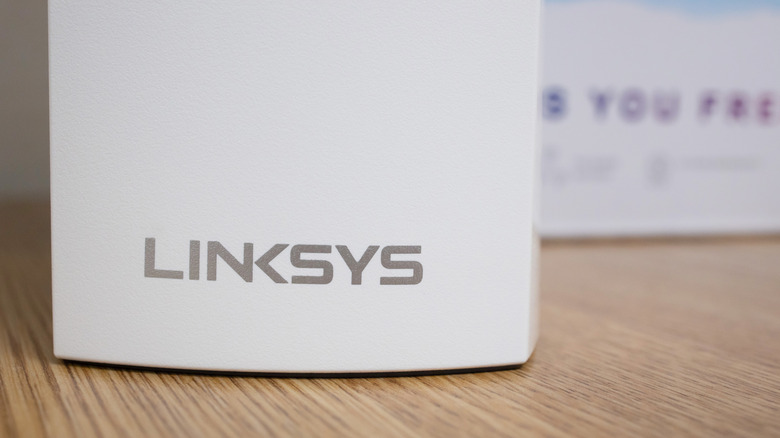 Close-up of a Linksys Mesh Wi-Fi router on a wooden table