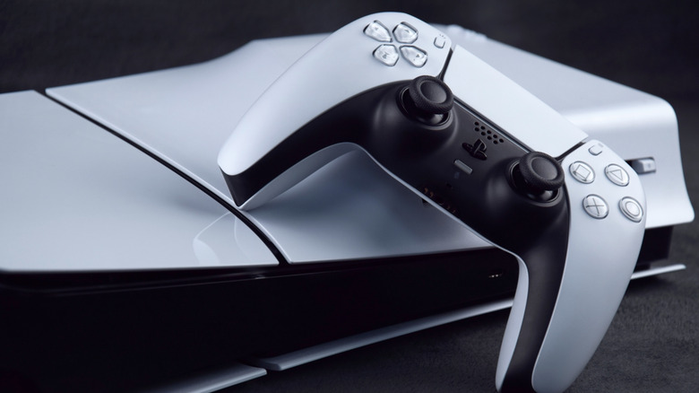 The PS5 Disc Edition turned upside down, with a controller next to it
