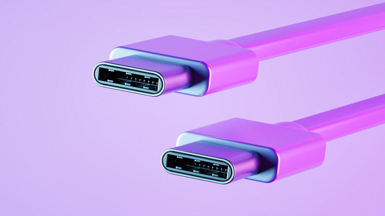 A close-up photograph of a USB-C cable connector with a purple background.