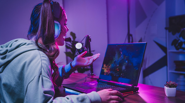 a young woman gaming on her laptop