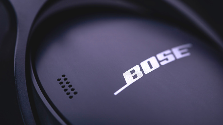 A close-up photo of the Bose logo on a pair of over-ear headphones