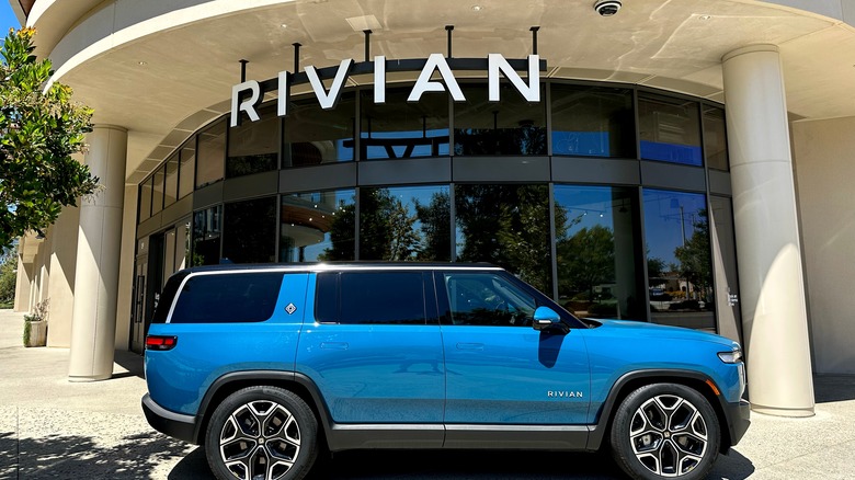 Blue Rivian car outside of a Rivian dealership