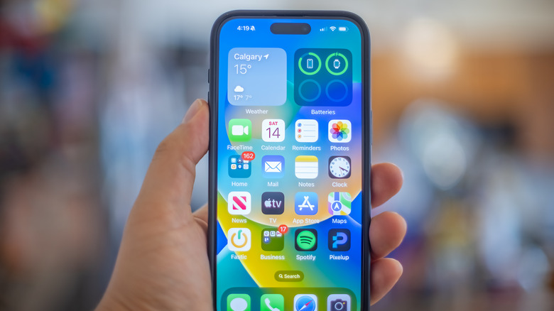 A hand holding an iPhone 15 Plus.