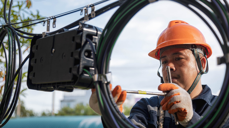 Technician working on a fiber optic cable and the related hardware.