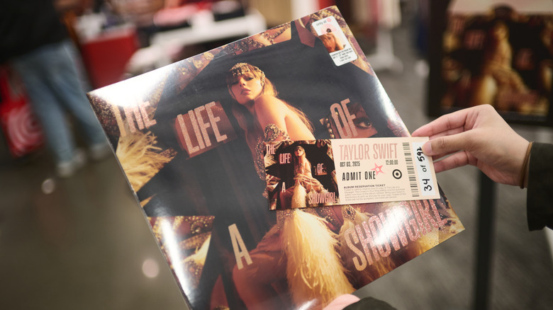 Person holding Taylor Swift vinyl album & ticket