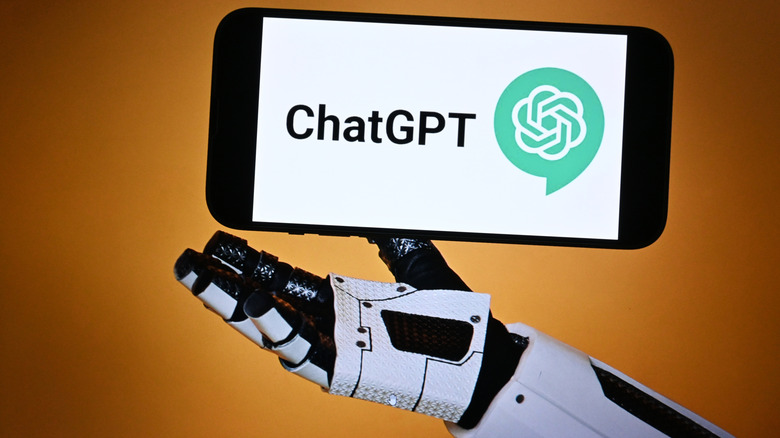 Robot hand holding smartphone with ChatGPT logo