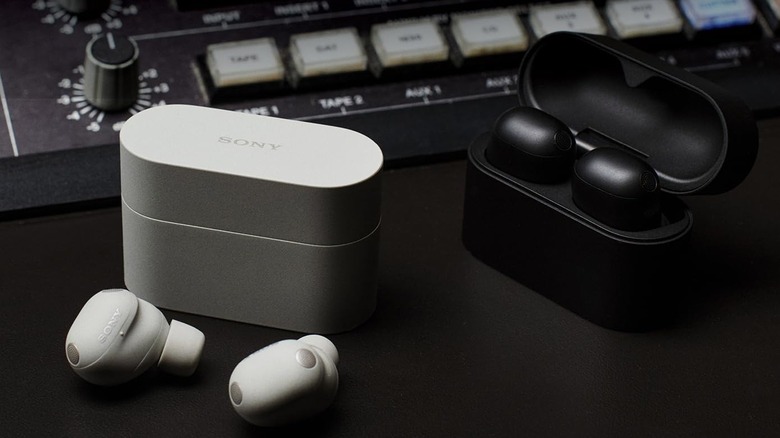 The Sony WF-1000XM6 in white and black. Both pairs are placed in front of a mixing board.