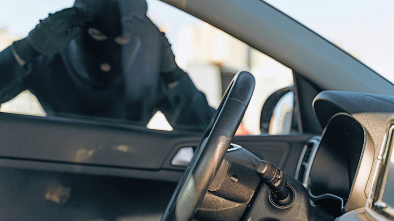 a car thief looking inside a car