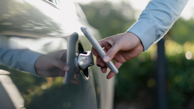 a man unlocks his car with a digital key on his phone
