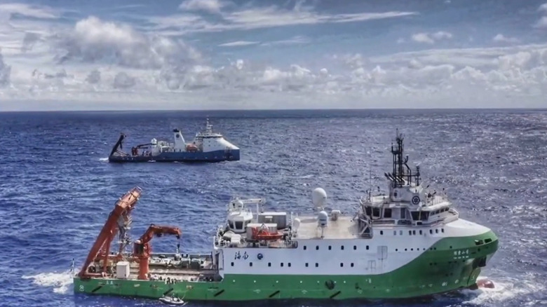A green and white Chinese research vessel, dubbed the Zhang Jian, sails through the New Britain Trench in the Solomon Sea, flanked by a support vessel.