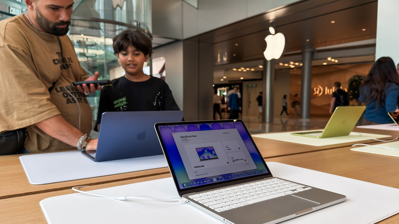 MacBook Neo laptops on display in an Apple retail store
