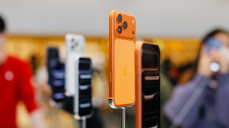 The iPhone 17 Pro on display in stores, with the Cosmic Orange version in focus.