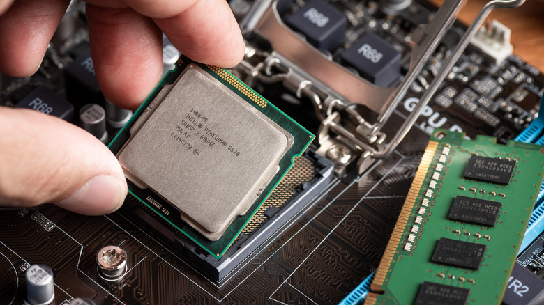 Person taking an Intel Pentium processor out of a motherboard