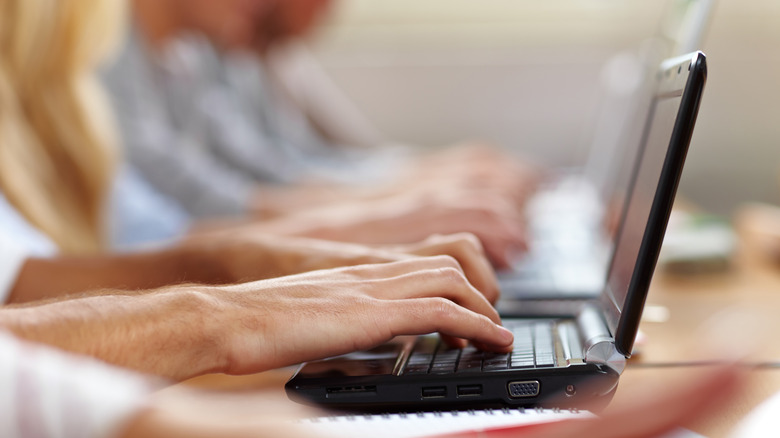 Close-up of hands typing on a netbook