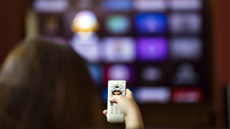 A person pointing a remote at a TV