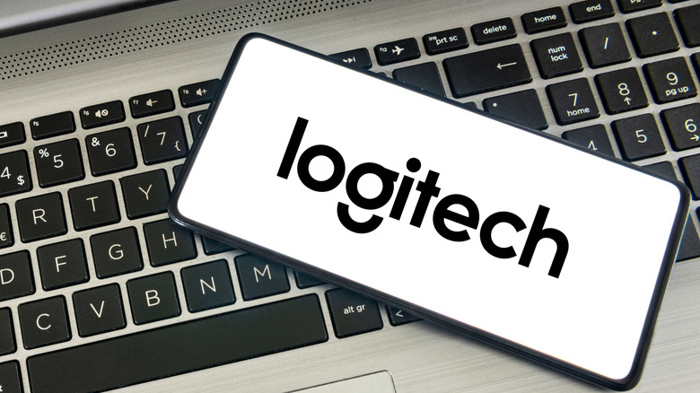 The Logitech logo on a phone atop a computer keyboard
