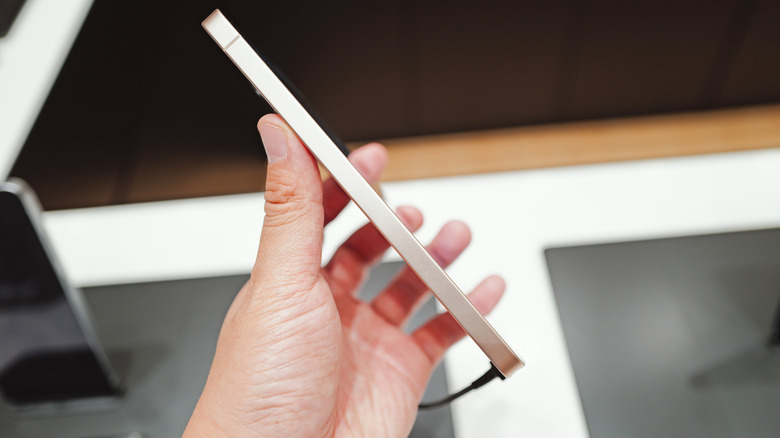 A Samsung Galaxy S26 Ultra held in the air with its thin design visible from the side.