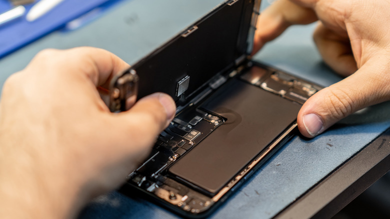 Repair technician replacing smartphone battery