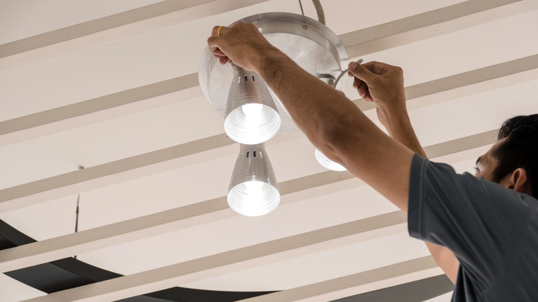 A person setting up LED ceiling lamps.