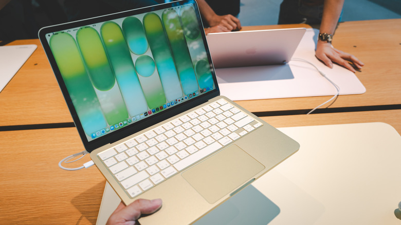 A person holding up a MacBook