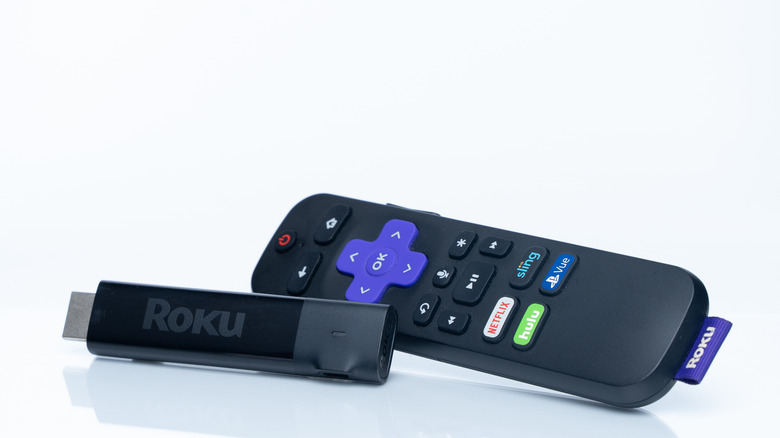 A Roku remote and HDMI stick on a white background.