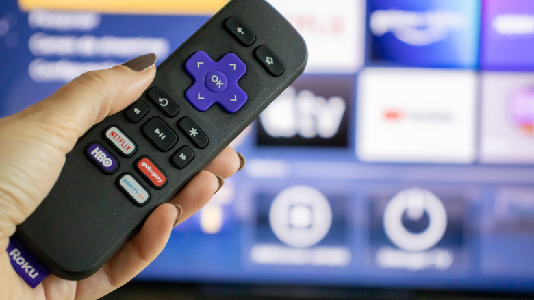 A Roku remote in a person's hand
