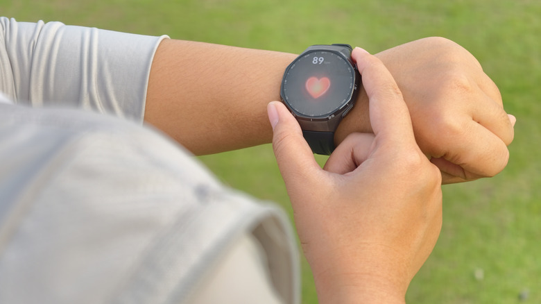 A person checking their heart rate on a smartwatch from their wrist.