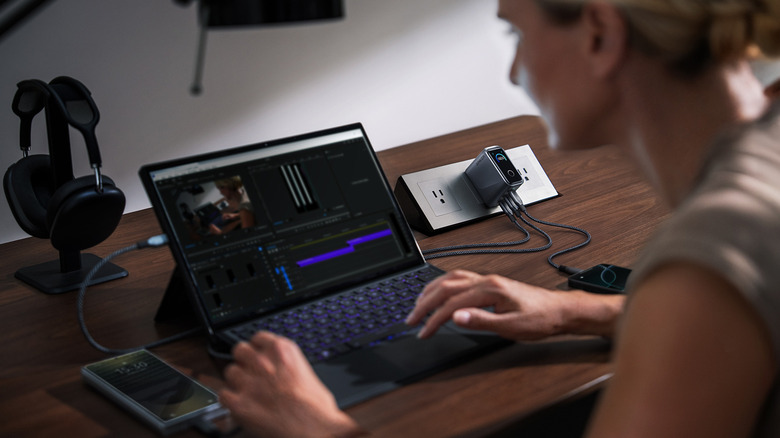 A woman on her laptop at home plugged into an Anker charger.