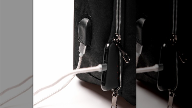 A phone in a backpack pocket connected to the backpack's USB port.