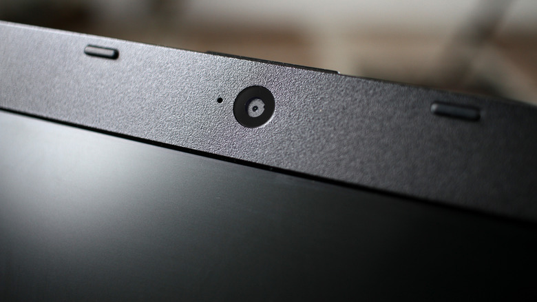 Close-up of a laptop's top bezel showing a hole next to the camera.