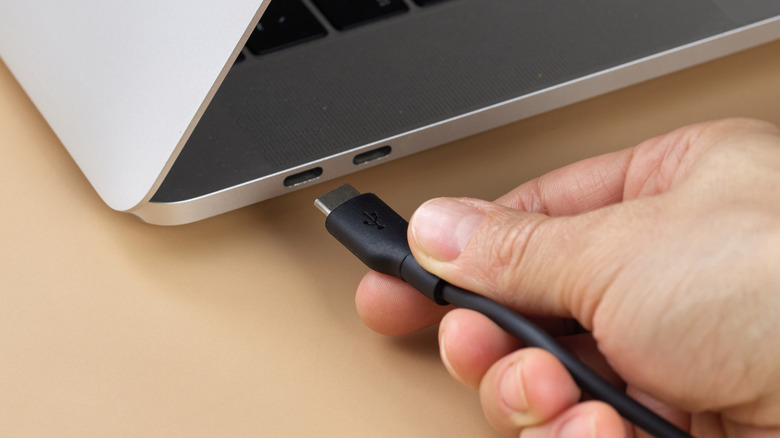 Person plugging in a laptop