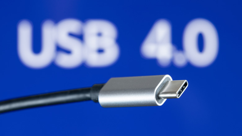 USB Type-C connector and cable in foreground with USB 4.0 title in background.