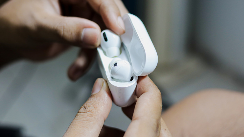 A person removing AirPods from their case