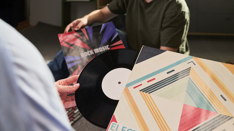 Two people sorting through vinyl records