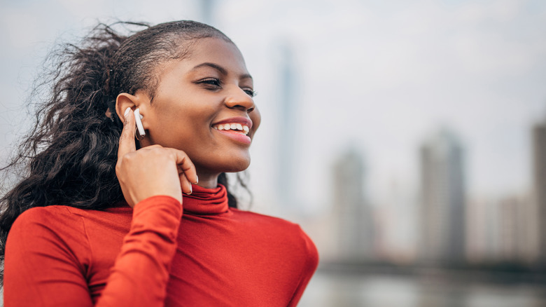 Someone tapping an earbud