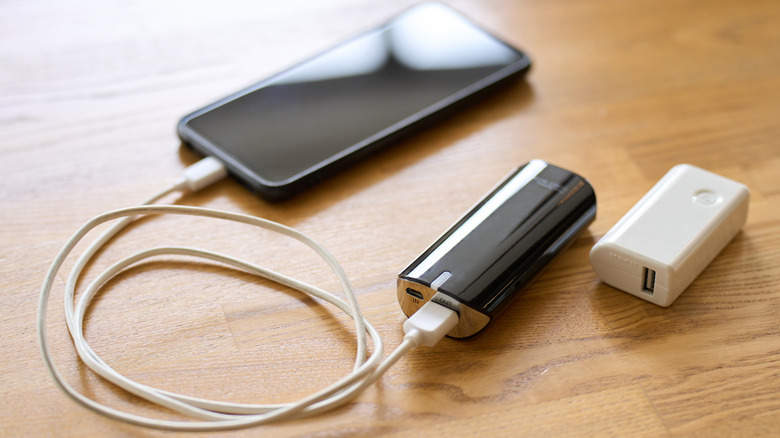 Phone on wooden table connected to power bank
